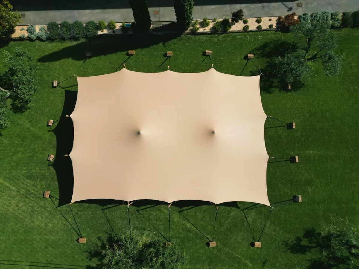 A stretch tent seen from above, pitched on a lawn